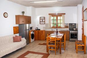 StrovlésAnastasia Country Home的厨房以及带桌子和沙发的客厅。