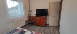 鲍洛托努德沃里Lali Apartman的卧室配有带电视的梳妆台和床
