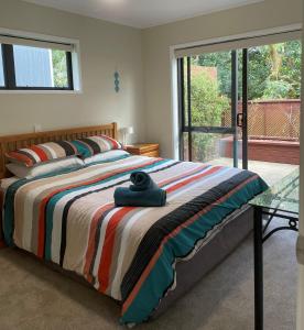 陶朗加Baybell Lodge的一间卧室配有一张带彩色毯子的床