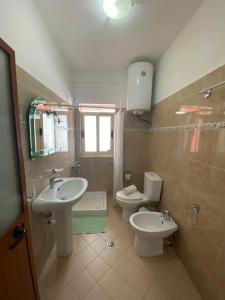 佩尔梅特Dhimitrulla Guest-House的一间带两个盥洗盆、卫生间和窗户的浴室