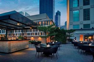 吉隆坡JW Marriott Kuala Lumpur的一个带桌椅的屋顶露台,位于大楼内