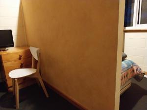 金德拜恩金达拜尼木屋旅馆的一间房间,墙上有一张桌子和一把椅子