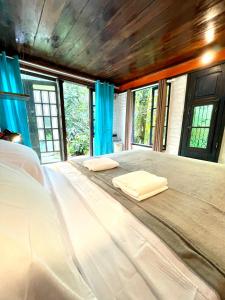 阿布拉奥Casa Selva - Vila do Abraão - Ilha grande的带窗户的客房内的一张大床和两个枕头