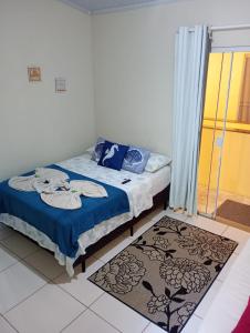 阿布拉奥Flats Jordão的一间卧室配有一张带蓝色床单的床和一扇窗户。