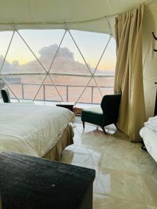 瓦迪拉姆Revan Rum Luxury Camp的客房设有两张床、一把椅子和窗户。