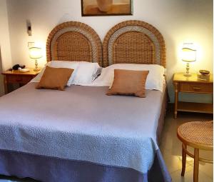 马尔米堡贝隆达酒店的一间卧室配有一张大床、两张桌子和两盏灯。