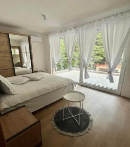 萨拉热窝Villa Rivus的一间卧室配有一张床、一张桌子和一个窗户。