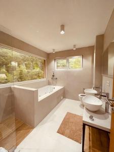 萨拉热窝Villa Rivus的浴室配有2个卫生间、浴缸和水槽