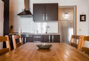 托莱多代盖坦公寓的厨房配有木桌和碗