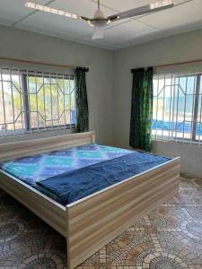 NyanyanuAnne’s Beach House的配有窗户的客房内的一张大床
