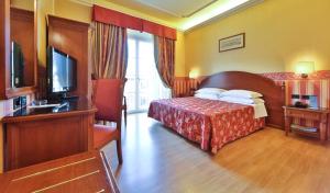 博洛尼亚Hotel San Donato - Bologna centro的酒店客房,配有床和电视