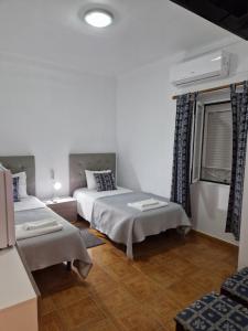 埃尔瓦斯Residencial Antonio Mocisso Guesthouse的一间卧室设有两张床和窗户。