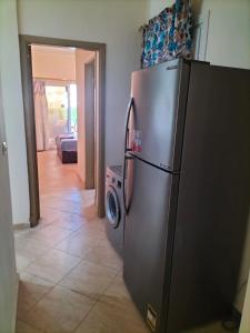 Abû Zeiraقرية ريماس الساحل الشمالي的厨房配有不锈钢冰箱和洗衣机。