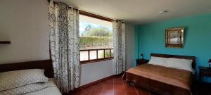 莱瓦镇Cabaña Campestre el Refugio的一间卧室设有一张床和一个美景窗户。