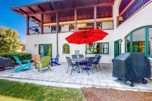 Eatonton Abruzzi - Villa B的庭院配有桌椅和红色遮阳伞。