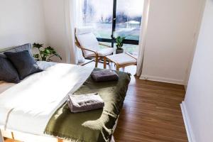 Port AdelaideBeachfront Escape的卧室配有床、椅子和窗户。
