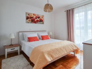 库希斯特Apartments by the sea Viganj, Peljesac - 16259的白色卧室配有红色枕头的床
