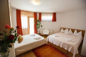 布拉索夫Charming Villa in a Private Mountain Resort的一间卧室设有两张床和花瓶