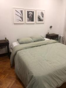 奥迪韦拉什Grandma`s house in Lisbon的卧室配有一张墙上三幅照片的床