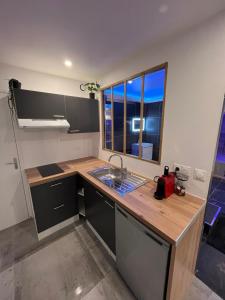 GargenvilleAzulik Spa & Jacuzzi privatif的一个带水槽和窗户的小厨房