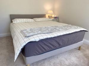 悉尼The South bay's home-Big RoomA的一间卧室配有一张带毯子和灯的床