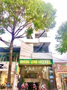 邦美蜀Hoàng Linh Hotel的前面有红线酒店标志的建筑