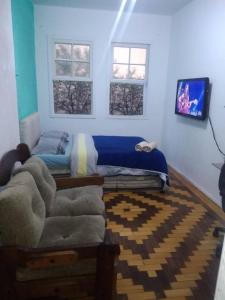 阿雷格里港Sobrado Tranquilo Centro的一间卧室配有一张床、一张沙发和两个窗户。