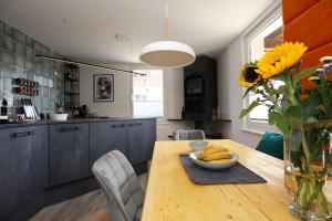 施卢赫湖BohoStyleApartment am See的厨房配有木桌和向日葵花瓶