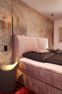 施卢赫湖BohoStyleApartment am See的一间卧室设有一张带混凝土墙的大床
