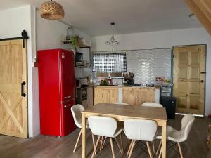 拉瑙The M Wanderlust Private Cabin的厨房配有木桌和红色冰箱。