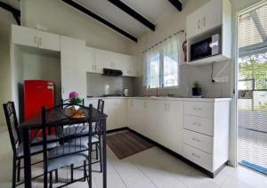 NausoriMohans Apartments的厨房配有桌子和红色冰箱