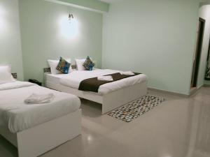 甘托克Hotel BJ的白色客房,配有两张床和地毯