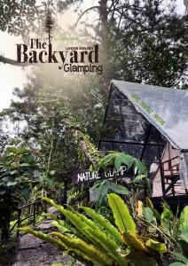 丹那拉打The Backyard Glamping Cameron Highlands的房屋旁的后院露营标志