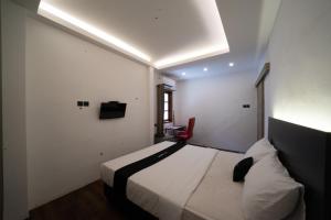 CandiDS Colive Sinabung的酒店客房,配有一张床和一张红色椅子