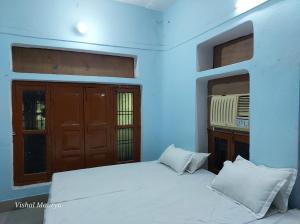 瓦拉纳西Maa Tara AC Home Stay的卧室配有白色的床和2扇窗户。