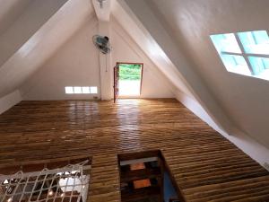 BarasL'Astrolabe - Tiny House的阁楼间铺有木地板,设有窗户。
