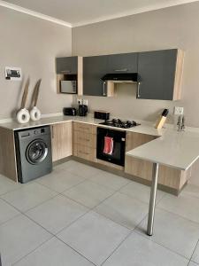 米德兰Ladybug unit 3 (2)的厨房配有炉灶和洗衣机。