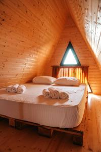 提斯基斯迪里Mandar Inn的木制房间的一个床位,上面有毛巾