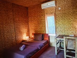 吉利阿尔吉利艾尔老村庄假日公园的一间卧室配有一张床和一个带风扇的窗户。