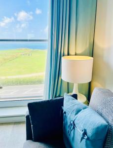 纽基Stunning Sea Views, luxury apartment beaches & restaurants are a short walk away的客厅设有蓝色的沙发和窗户。
