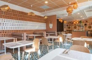 勒图凯-巴黎普拉日Ibis Styles Le Touquet的一间带桌椅的餐厅以及砖墙