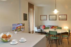 巴多利诺Ancora Suites的厨房以及带桌椅的起居室。