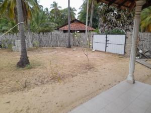 卡尔皮蒂耶Rosa Kusum Vacation Home Near Kudawa Beach In Kalpitiya的一个带栅栏和棕榈树的院子