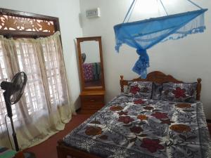 卡尔皮蒂耶Rosa Kusum Vacation Home Near Kudawa Beach In Kalpitiya的一间卧室配有一张床和镜子