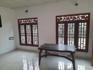 卡尔皮蒂耶Rosa Kusum Vacation Home Near Kudawa Beach In Kalpitiya的客房设有木桌和2扇窗户。