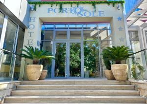 苏托莫雷Hotel Porto Sole的门前有盆栽植物的商店的门