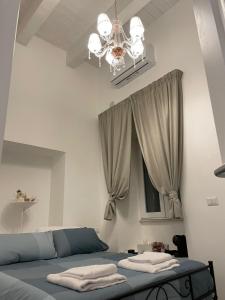 巴列塔CasArcieri72的一间卧室配有一张带吊灯和窗户的床。