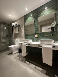 库迪列罗Hotel El Rosal de Cudillero的浴室设有2个水槽、卫生间和镜子。