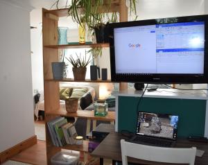 霍斯赫斯The Owl Box: self-contained private annex & garden的电脑显示器,坐在桌子上,手提电脑