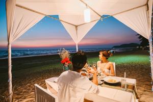 柴老海滩昭佬托桑海滩飯店的坐在海滩桌子上的男人和女人